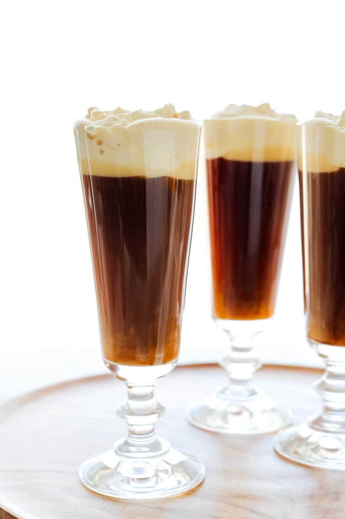  Pouring the cream over the back of a spoon is the key to achieving the classic look of an Irish Coffee.
